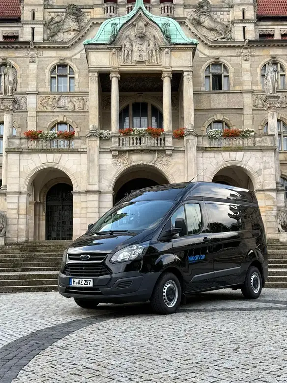 Ein schwarzer Kleinbus steht vor dem Rathaus Hannover
